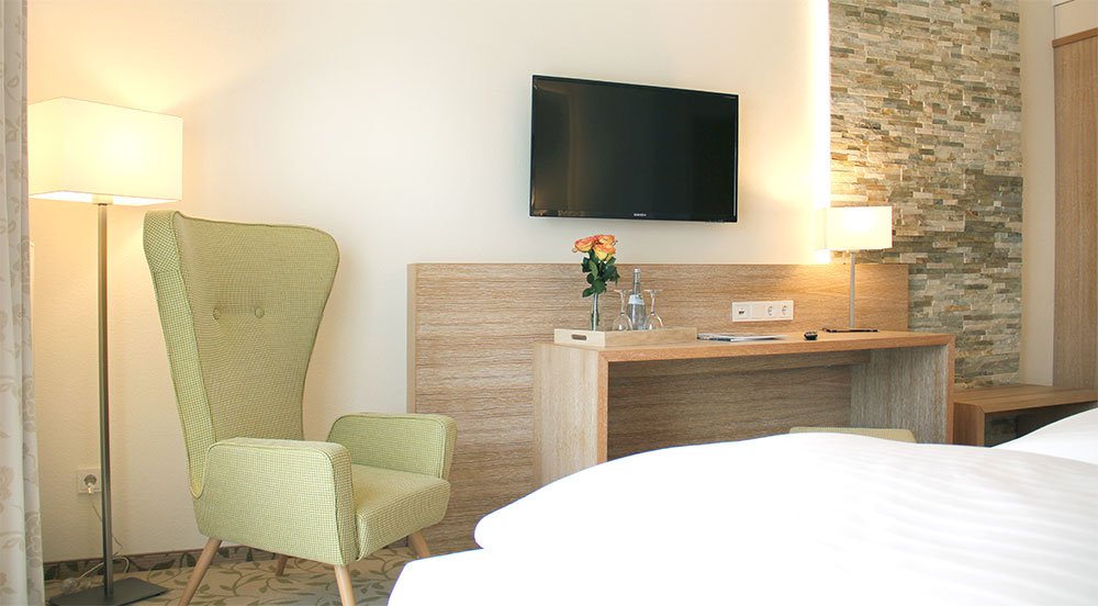 Zimmer mit Sessel und Schreibtisch